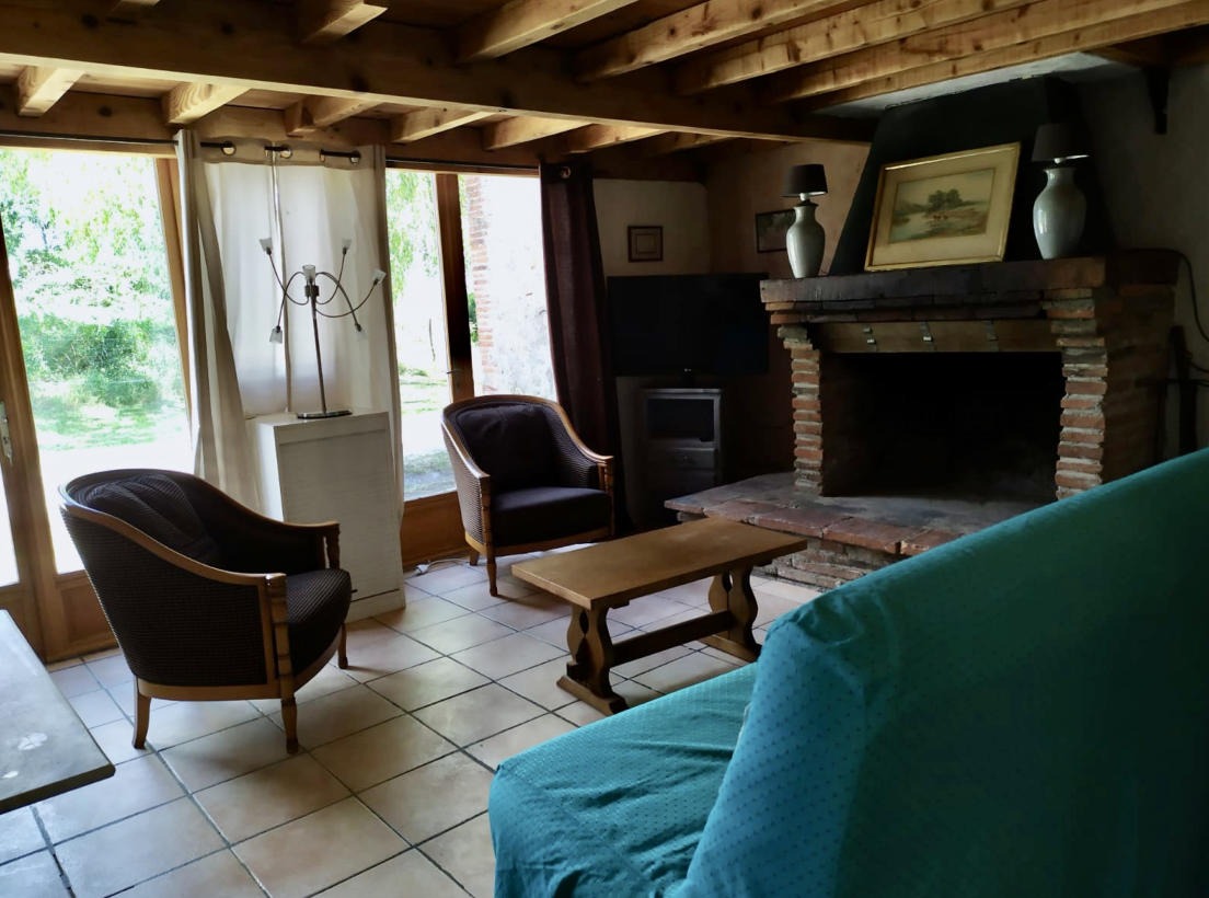 séjour avec fauteuils et canapé et cheminée