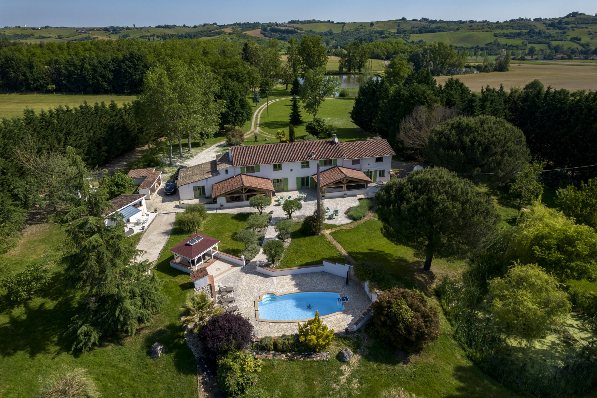 Vue aérienne du domaine avec grand parc arboré et piscine